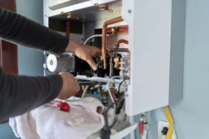 A technician repairs a gas boiler inside a residential home, ensuring proper functionality and safety.